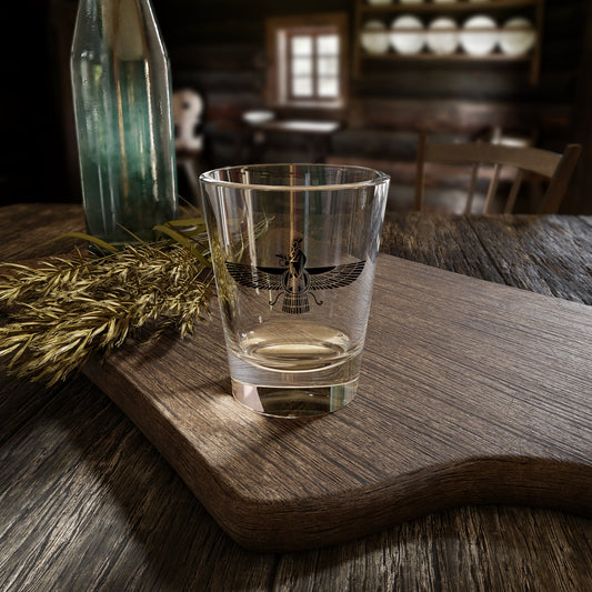 Clear glass with a Farvahar design on a wooden tray in a rustic setting