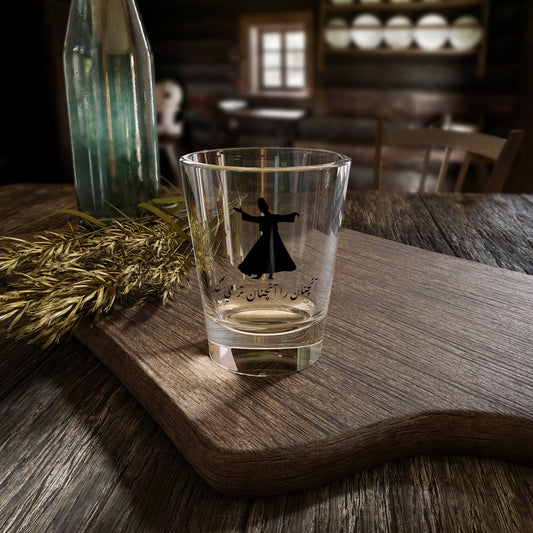 Clear glass with a black design of a Darvish doing Sama dance on a wooden tray in a rustic setting
