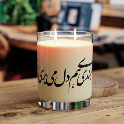 Candle with Farsi text on a wooden surface, blurred background
