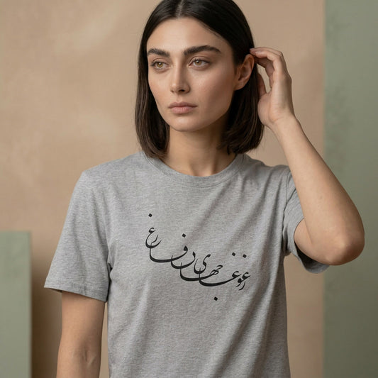 Woman wearing a gray t-shirt with Farsi calligraphy against a beige background
