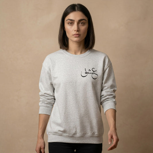 Person wearing a gray sweatshirt with Farsi text on a beige background