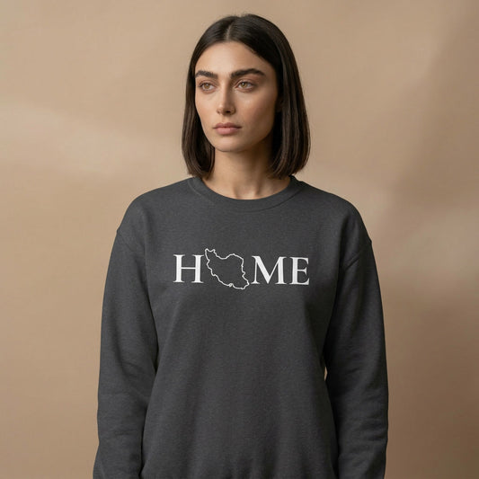 Person wearing a dark gray sweatshirt with 'HOME'  and Iran's map printed on it against a beige background