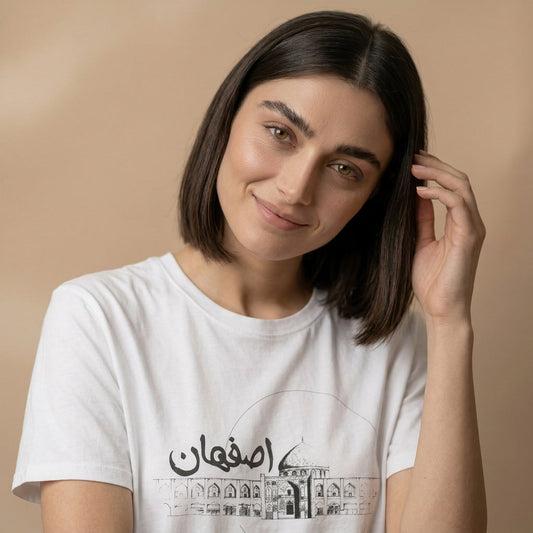 Woman wearing a white t-shirt with Isfahan name text and design on a beige background