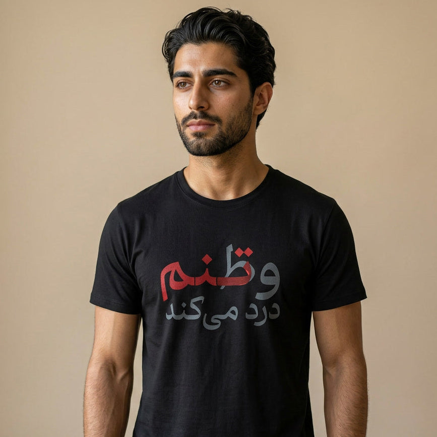 Man wearing a black t-shirt with Farsi text on a beige background