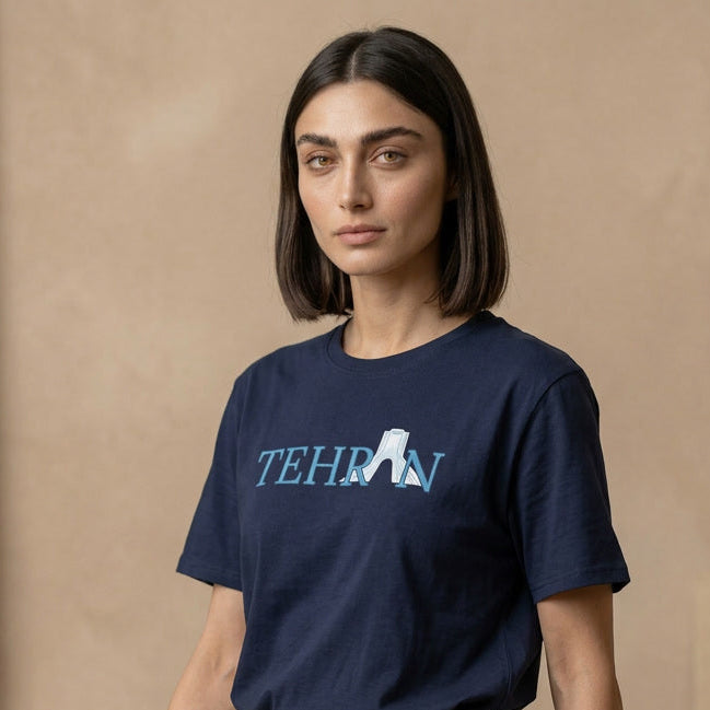 Person wearing a navy blue t-shirt with 'TEHRAN' printed on it against a beige background