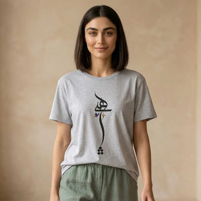 Woman wearing a gray t-shirt with Farsi Persian Hich calligraphy design against a beige background