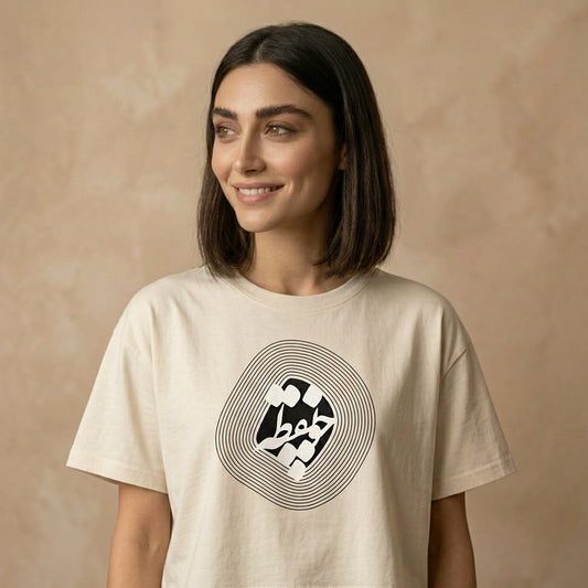 Woman wearing a beige t-shirt with a graphic design and چو نقطه  in Farsi Persian on the chest on a beige background